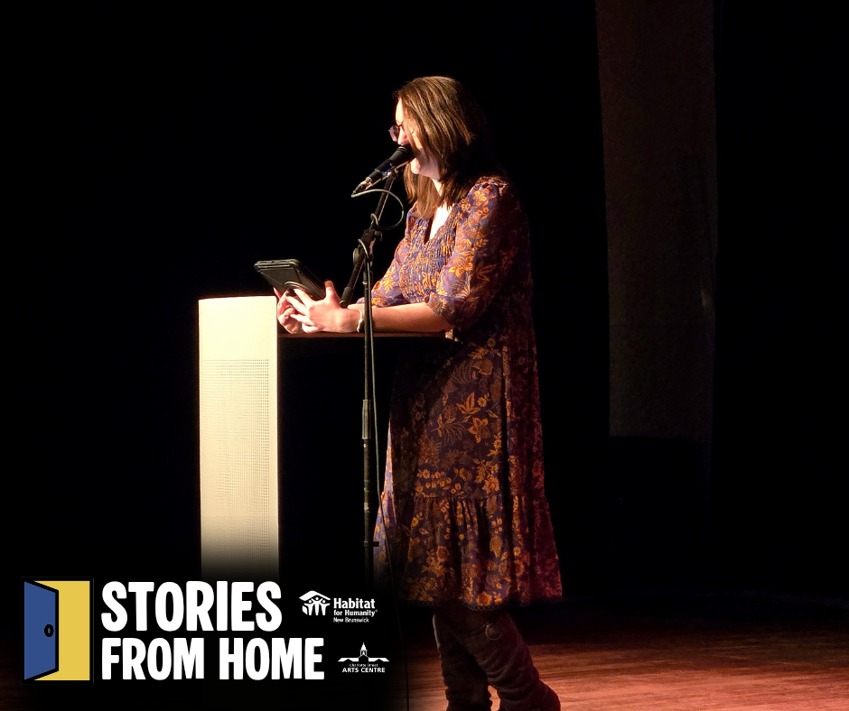 Woman speaking at a podium on a dark stage during a Stories from Home event