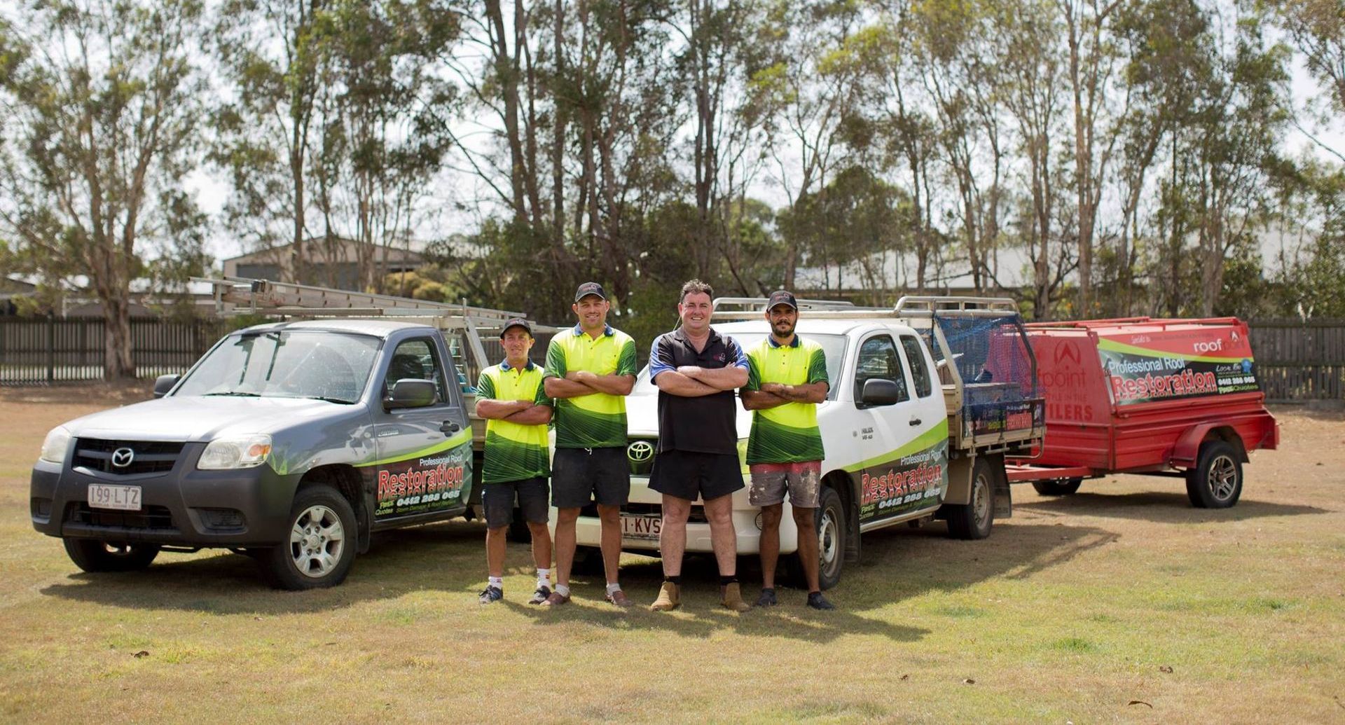 a team of workers standing in front of work vehicles — Roofpoint In Kawungan, QLD