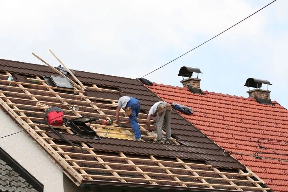 Two Men Are Working On The Roof Of A House — Roofpoint In Kawungan, QLD