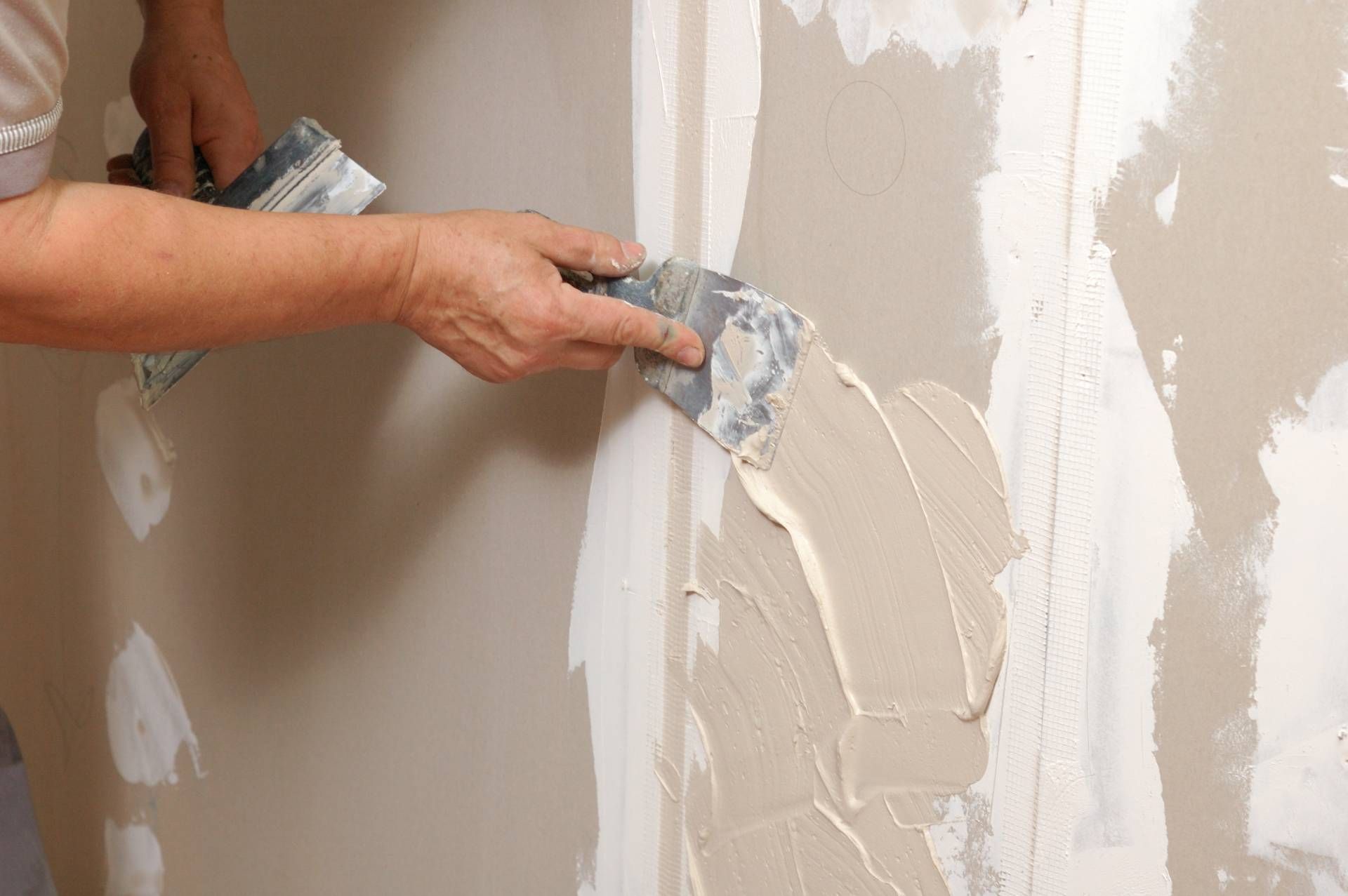 A man is hammering a nail into a piece of wood.