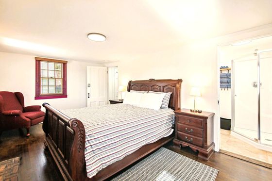 Ground-level haven with rustic charm. This first-floor suite features an original brick fireplace w/ a plush king-size bed.
