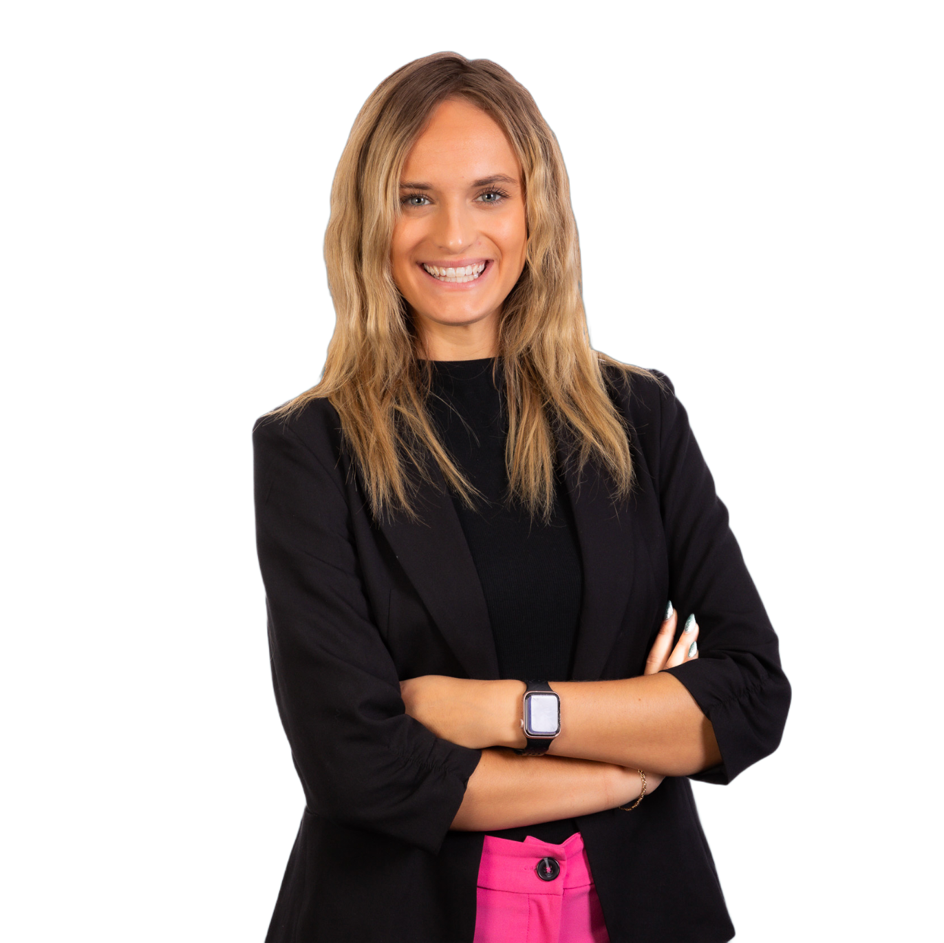 Smiling woman in a black blazer with arms crossed, wearing a pink skirt on a white background