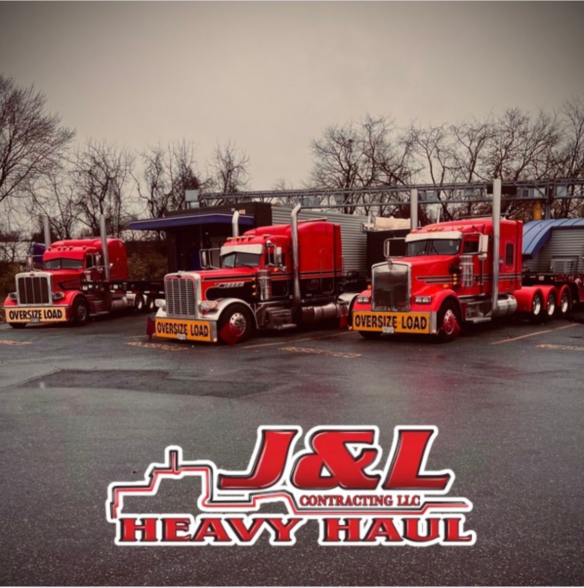 J&L Heavy Haul logo with three red semi trucks parked in front of a gray, leafless lot