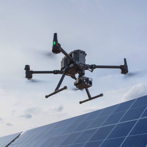 A drone is flying over a solar panel roof.