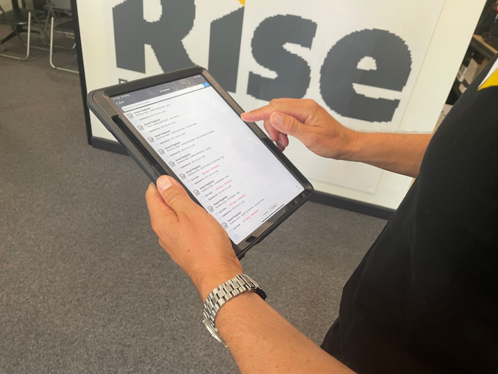 Rise team holding Ipad demonstrating custom large-asset inspection platform. 