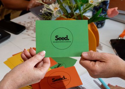 Pile of gold coins with a small green plant growing from the center, symbolizing financial growth.