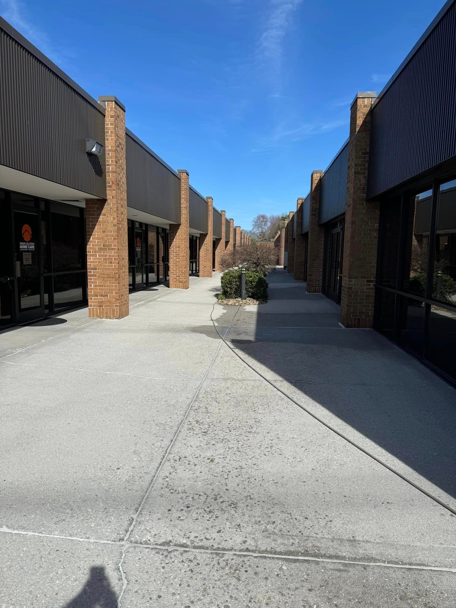 A row of brick buildings with a concrete walkway between them