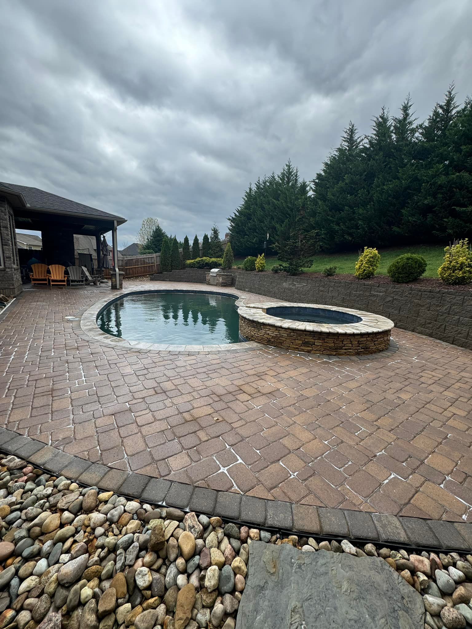 There is a swimming pool and a hot tub in the backyard.