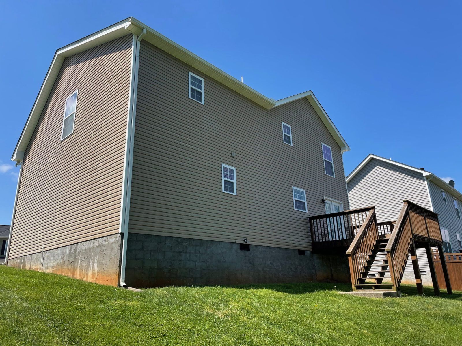 The back of a house with a deck and stairs.