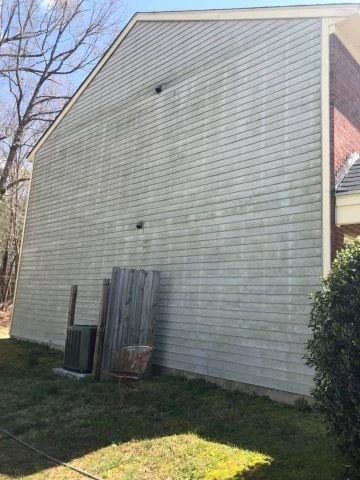 A large white house with a fence in the backyard.