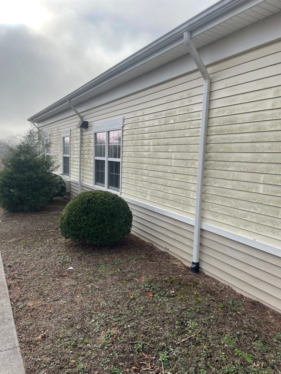 A large building with a lot of windows and a gutter on the side of it.