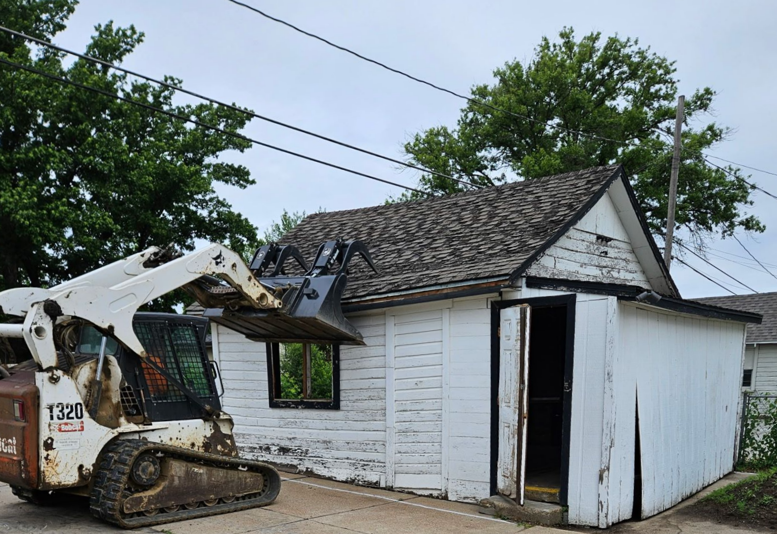 Two construction workers using jackhammers on concrete, creating dust clouds.
