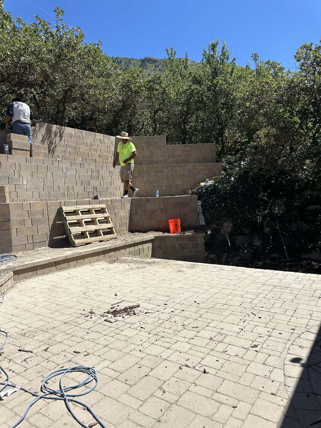 A man is standing on top of a brick wall.