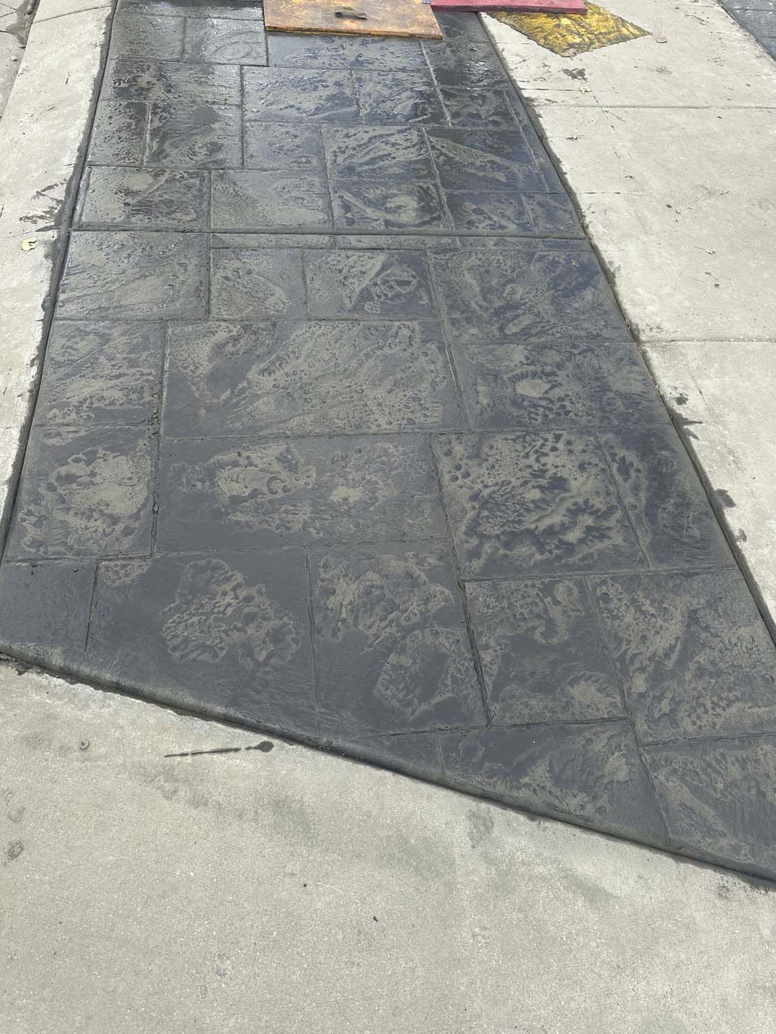 A concrete sidewalk with a slight curve in the middle of it.