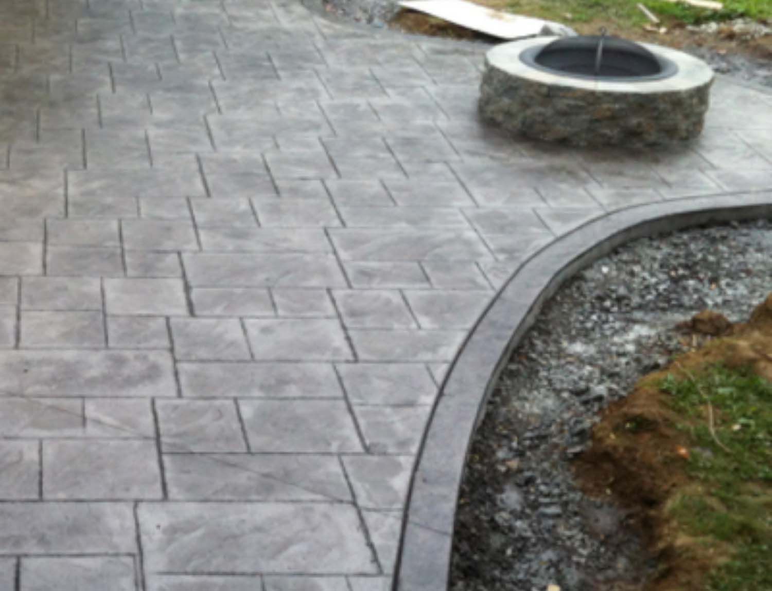 A concrete walkway with a fire pit in the middle