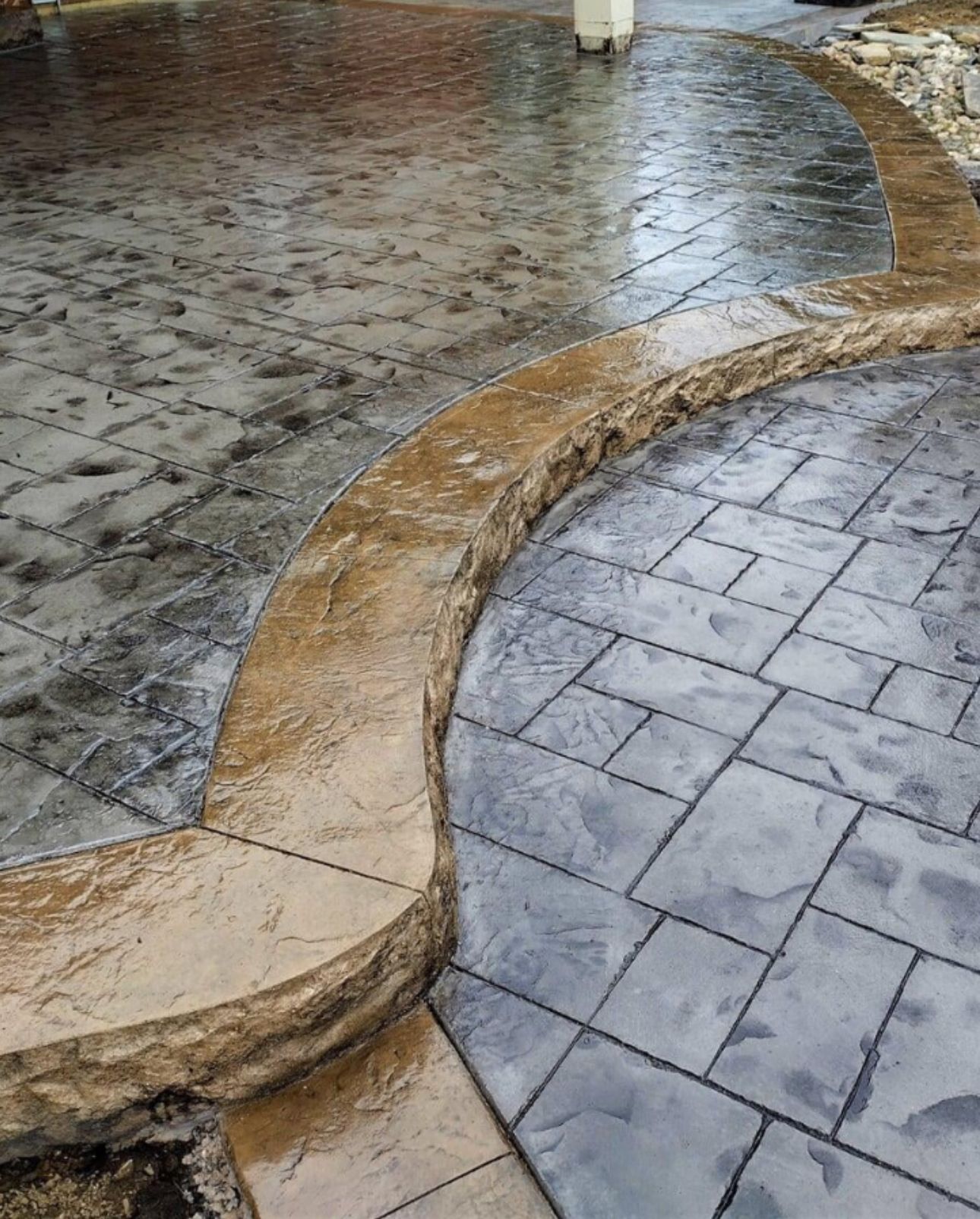 A close up of a concrete walkway with a stone border.