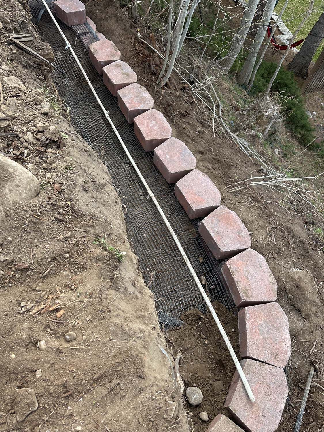 A row of bricks sitting on top of a dirt hill.