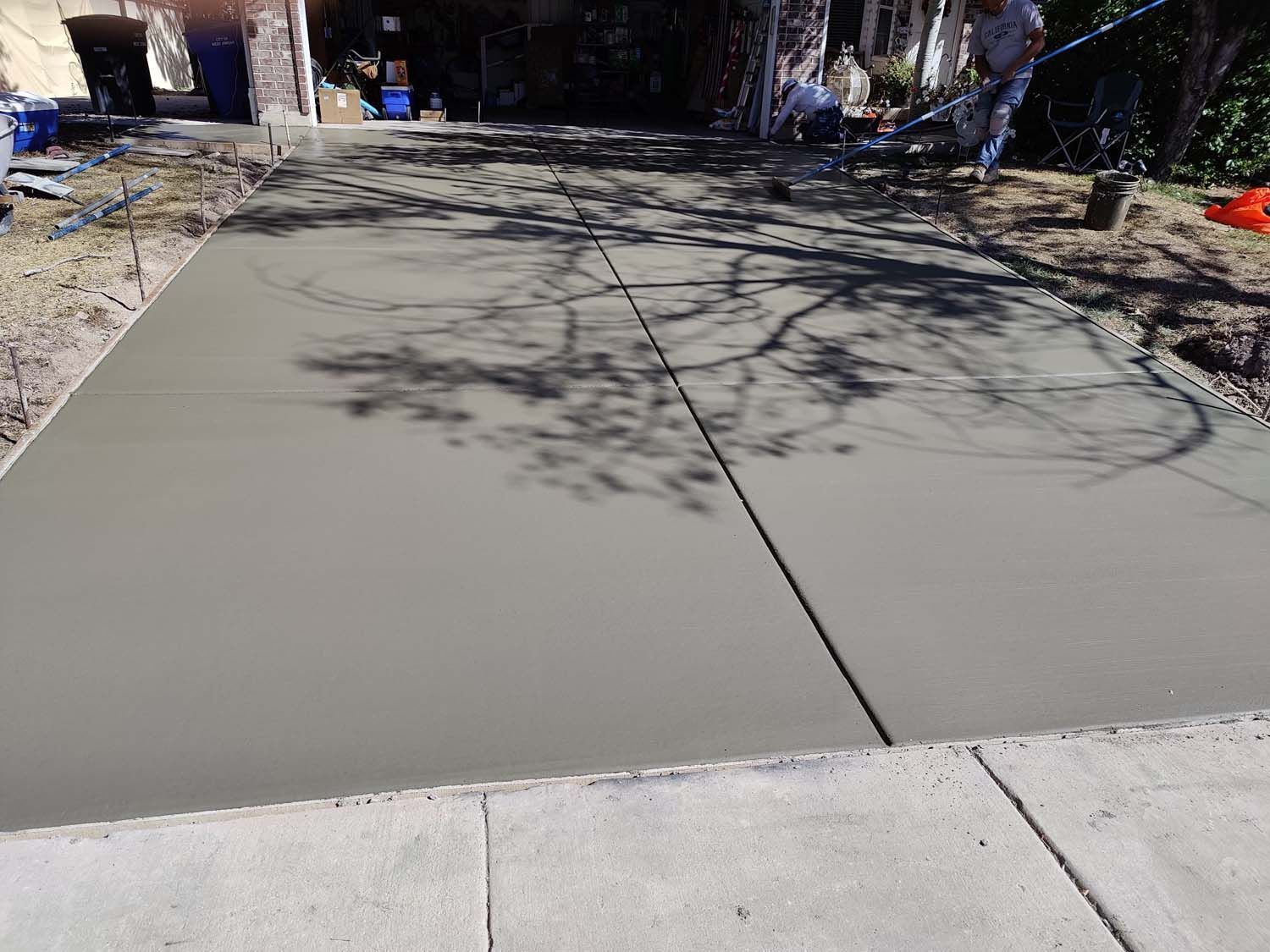A concrete driveway is being built in front of a house.