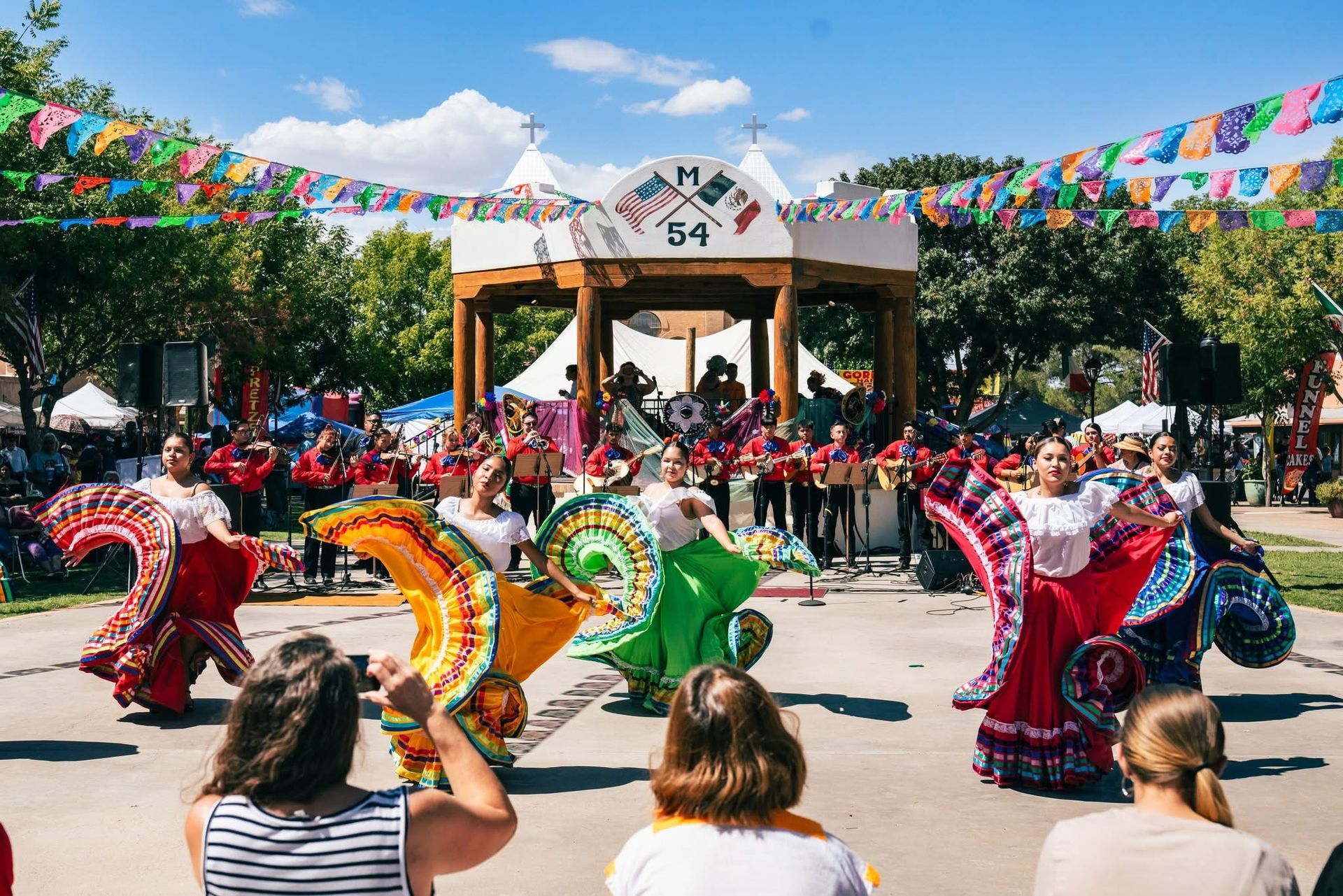 A group of people are dancing in front of a crowd at a festival.
