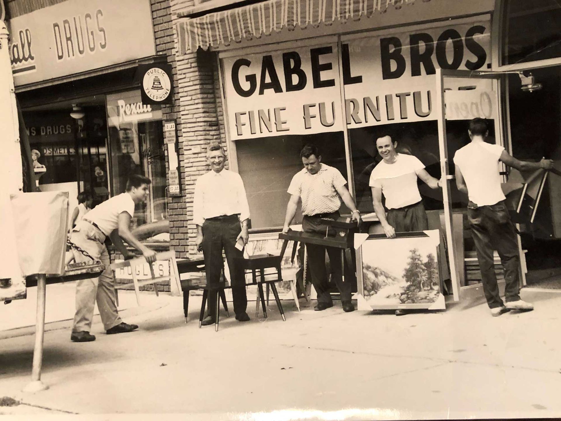 Men moving furniture outside a shop,