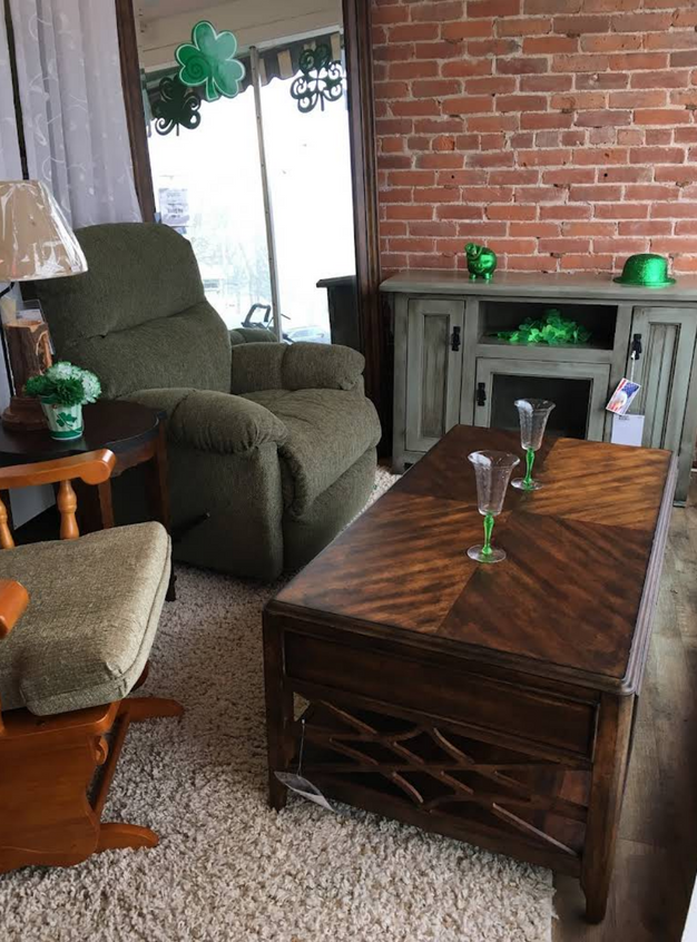 Cozy living room decorated for St. Patrick's Day with green accents, recliner, and wooden furniture.