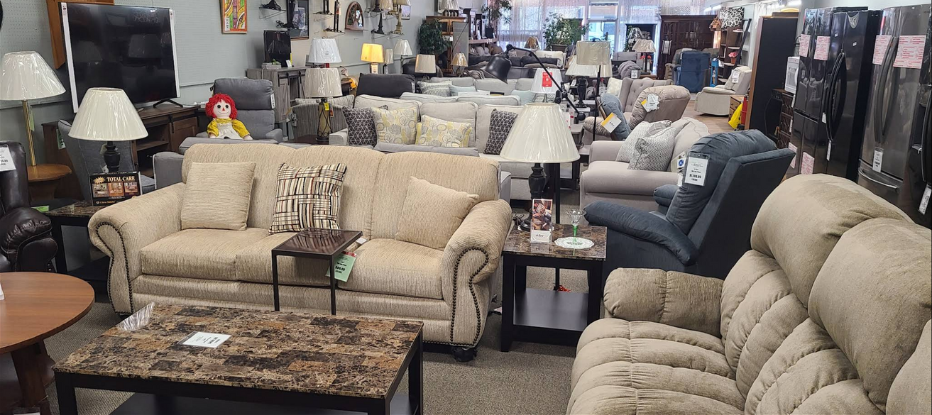 Interior of a furniture store filled with sofas, lamps, and tables.