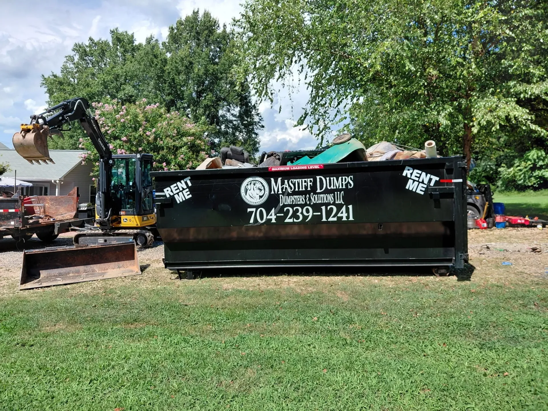 A dumpster is parked in front of a house.