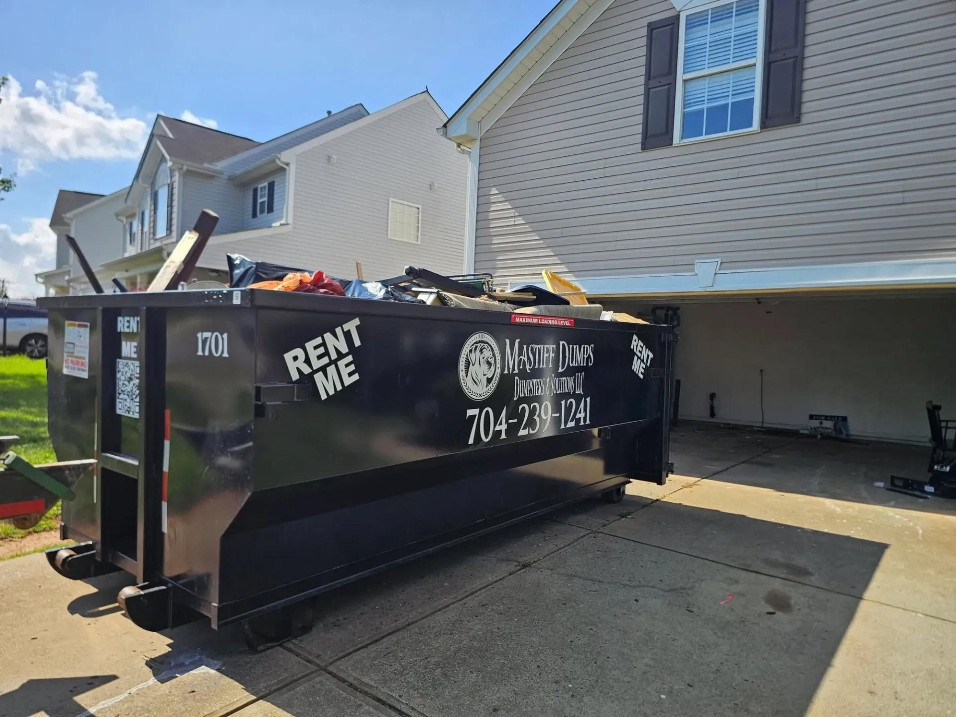 A dumpster is parked in front of a house.