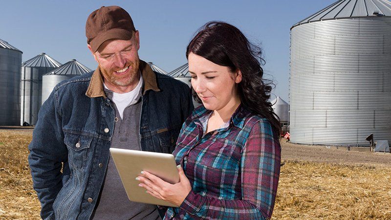 man talks to woman holding a notebook