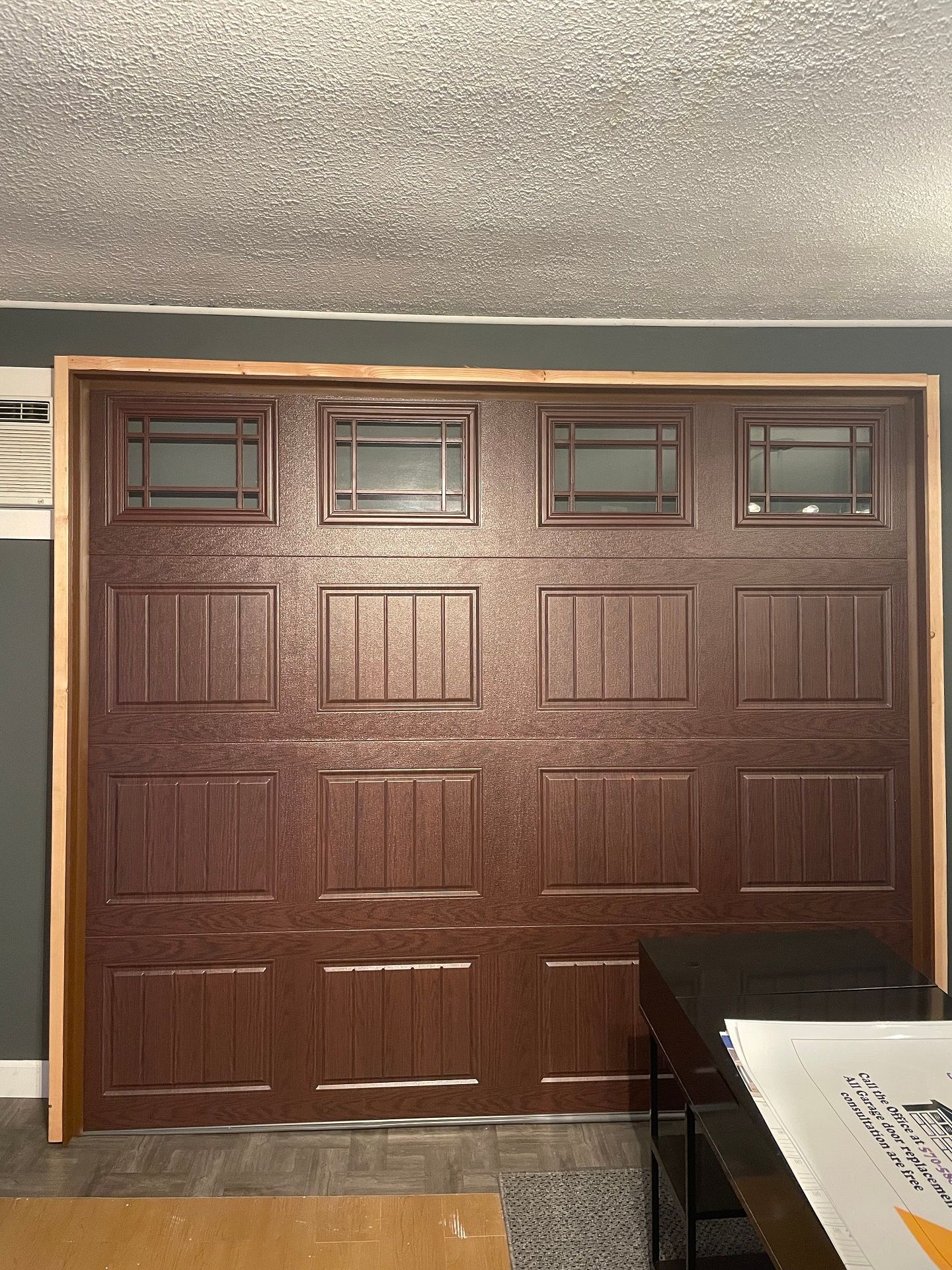 Brown garage door with four small windows at the top in a home interior.