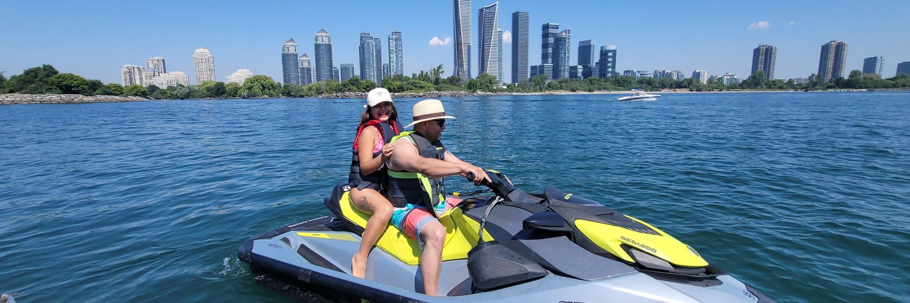A man and a woman are riding a jet ski in the water.