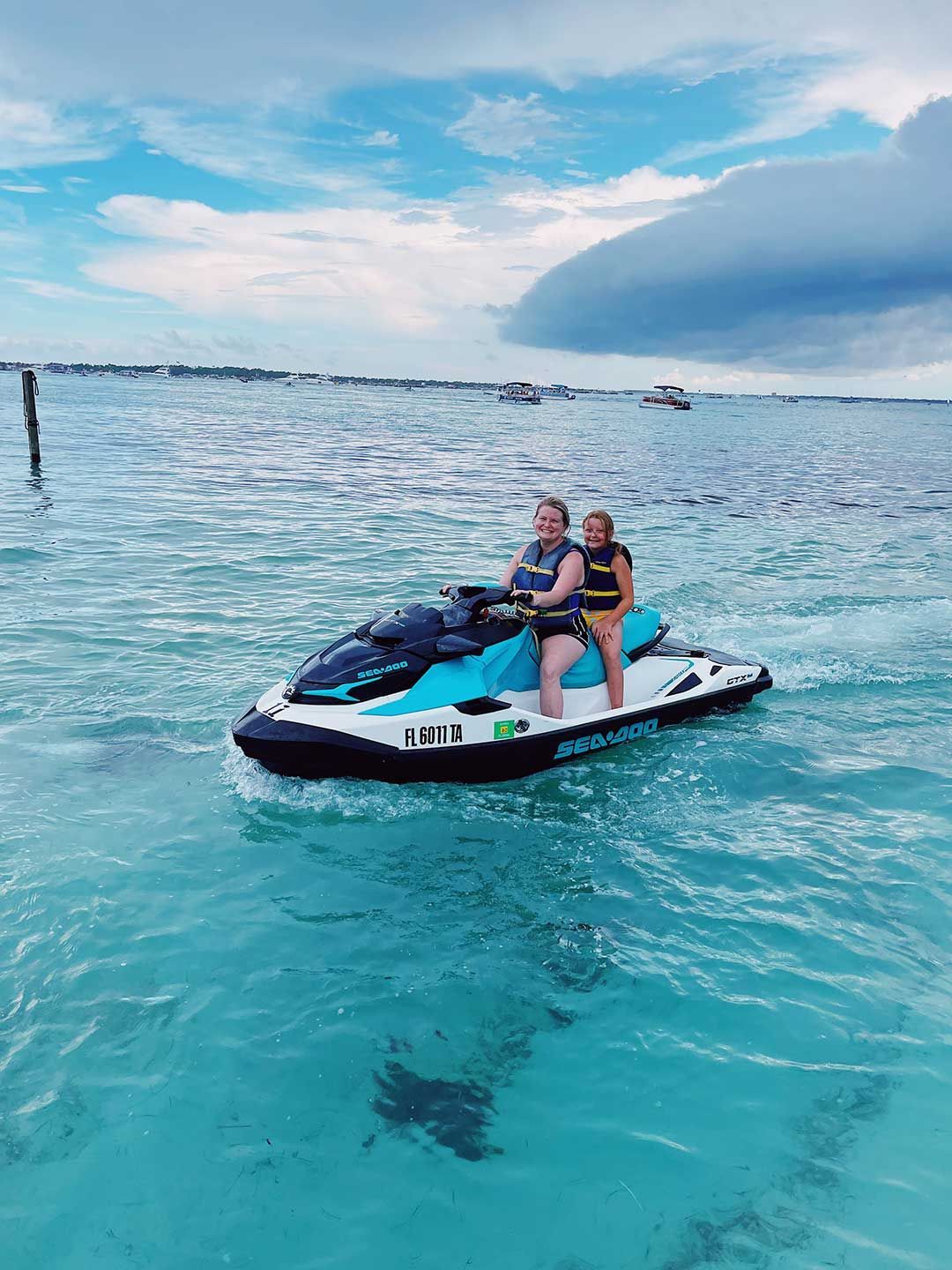 Two people are riding a jet ski in the ocean.