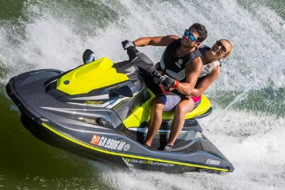 A man and a woman are riding a jet ski on a lake.