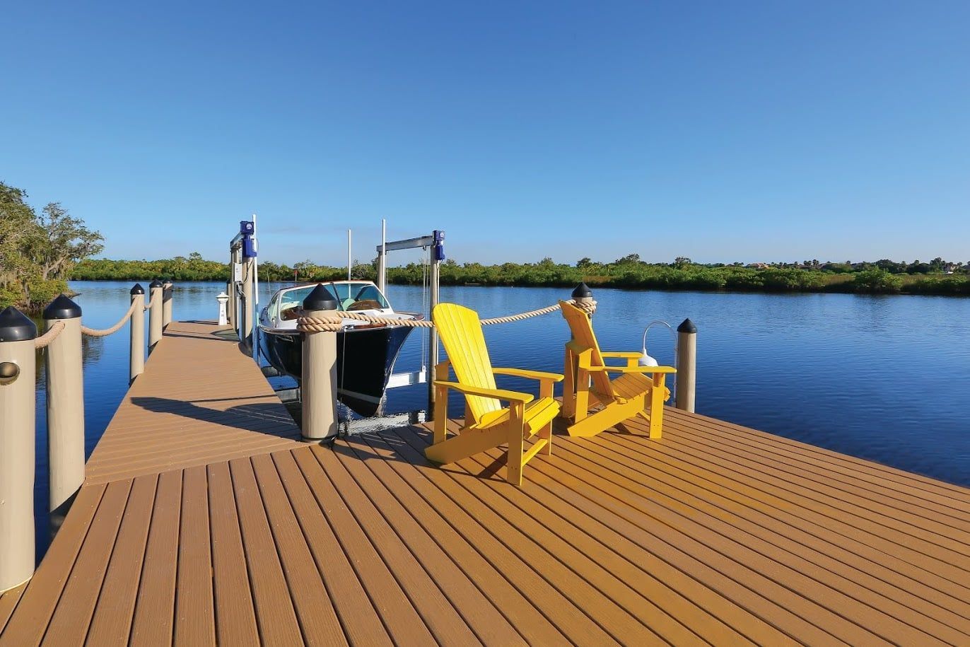 Yellow chairs on a wooden dock overlooking calm blue water under a clear sky