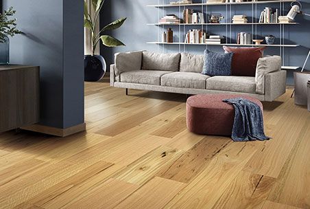 A Living Room With Hardwood Floors And A Couch — Mid Coast Flooring & Blinds In Forster, NSW