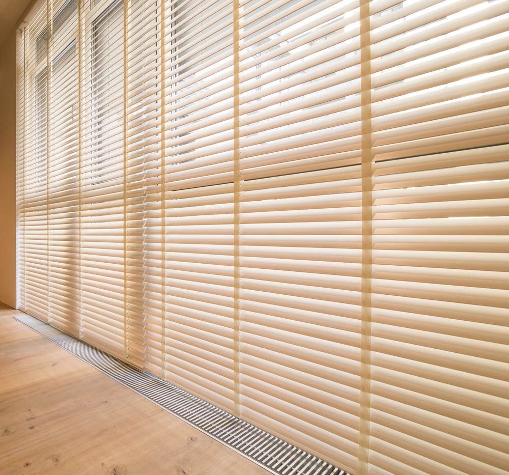 A Large Window with Blinds on It and A Wooden Floor — Mid Coast Flooring & Blinds In Wingham, NSW