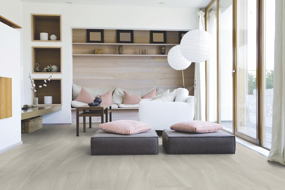 A Living Room With A Couch And Two Ottomans On The Floor — Mid Coast Flooring & Blinds In Taree, NSW