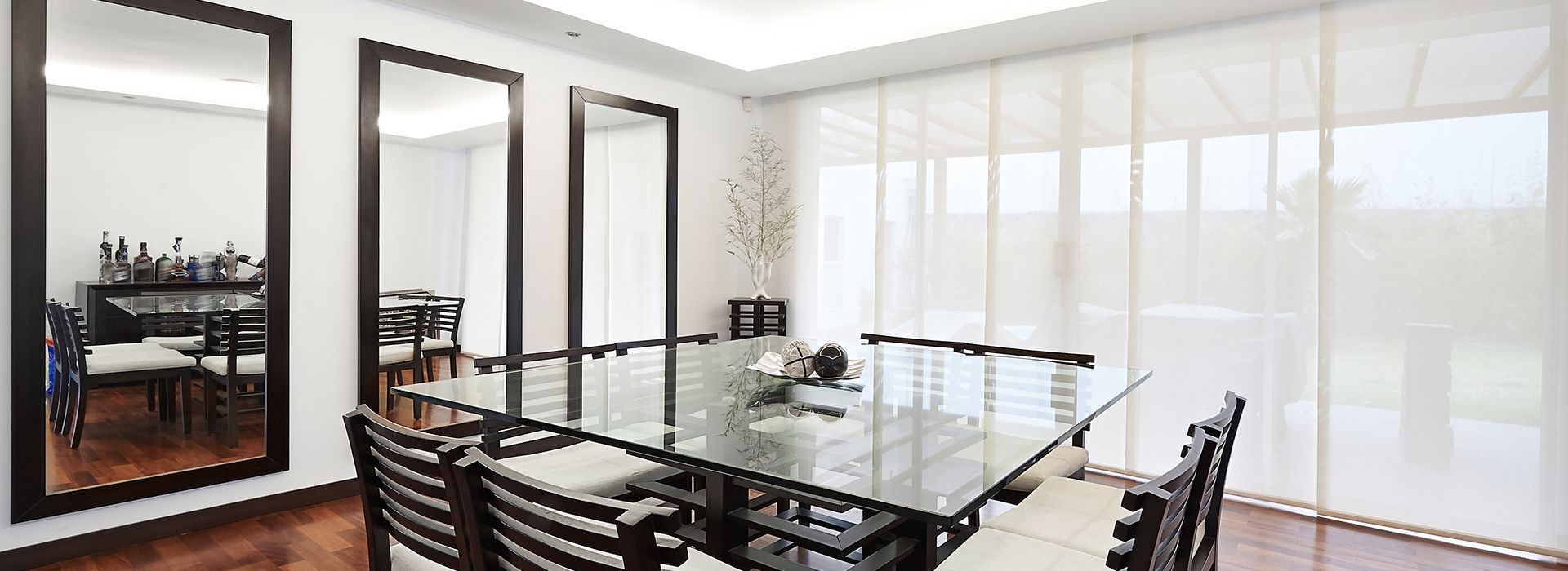 A Dining Room With A Large Glass Table And Chairs — Mid Coast Flooring & Blinds In Harrington, NSW