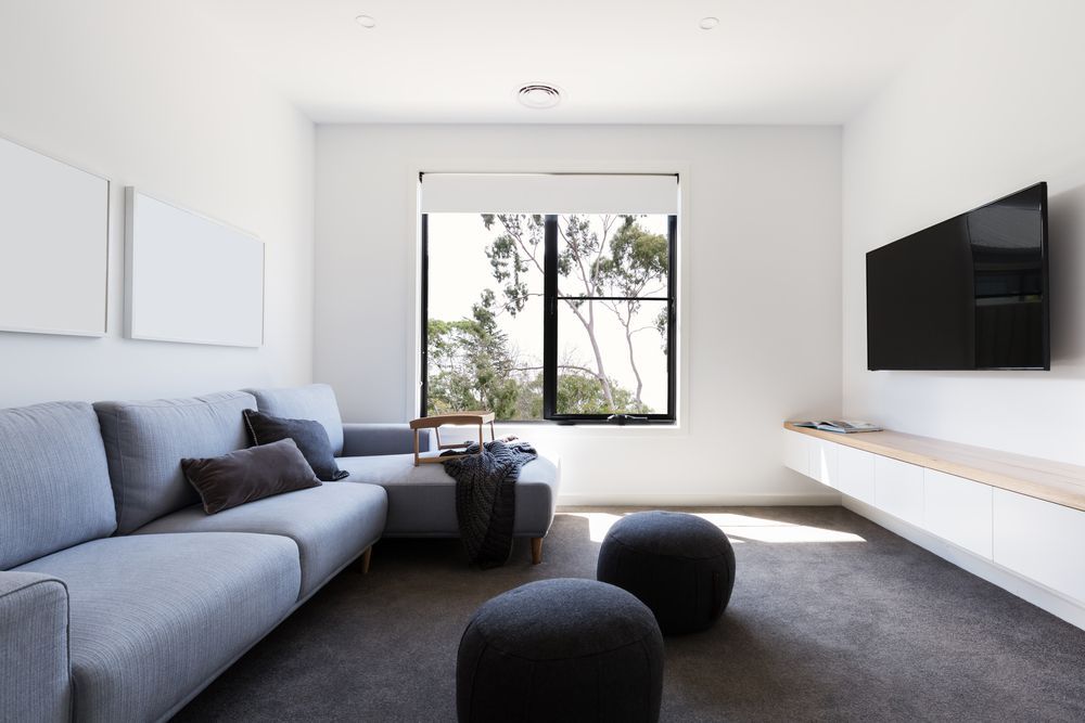 A Living Room With A Couch And A Flat Screen TV — Mid Coast Flooring & Blinds In Wingham, NSW