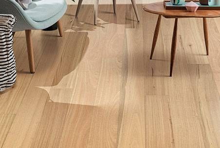 A Wooden Floor Is Being Installed On A Concrete Floor — Mid Coast Flooring & Blinds In Taree, NSW