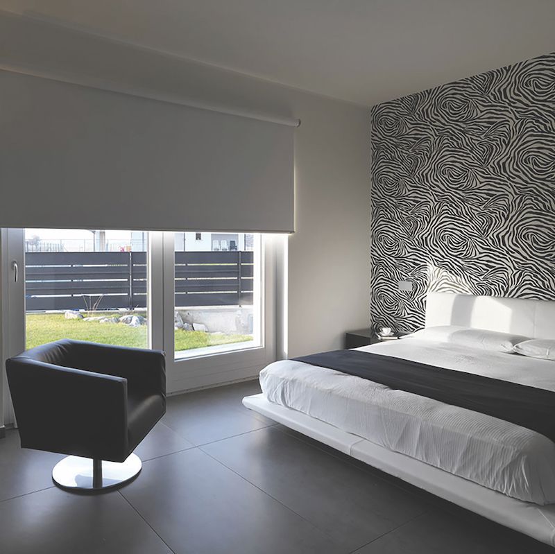 A Bedroom With A Large Bed And A Chair — Mid Coast Flooring & Blinds In Harrington, NSW