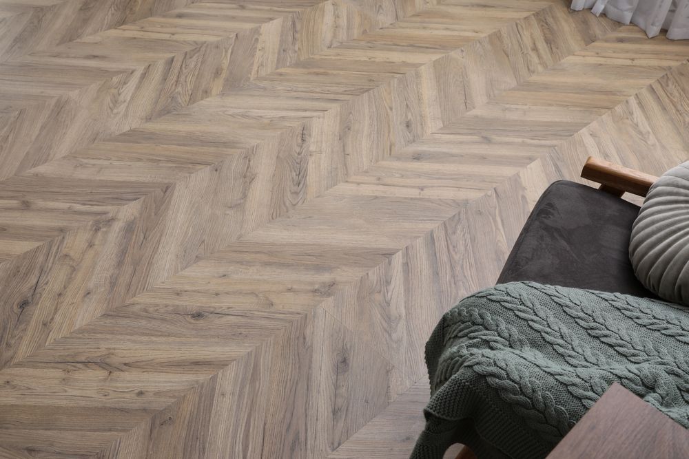 A Wooden Floor With A Herringbone Pattern In A Living Room — Mid Coast Flooring & Blinds In Taree, NSW