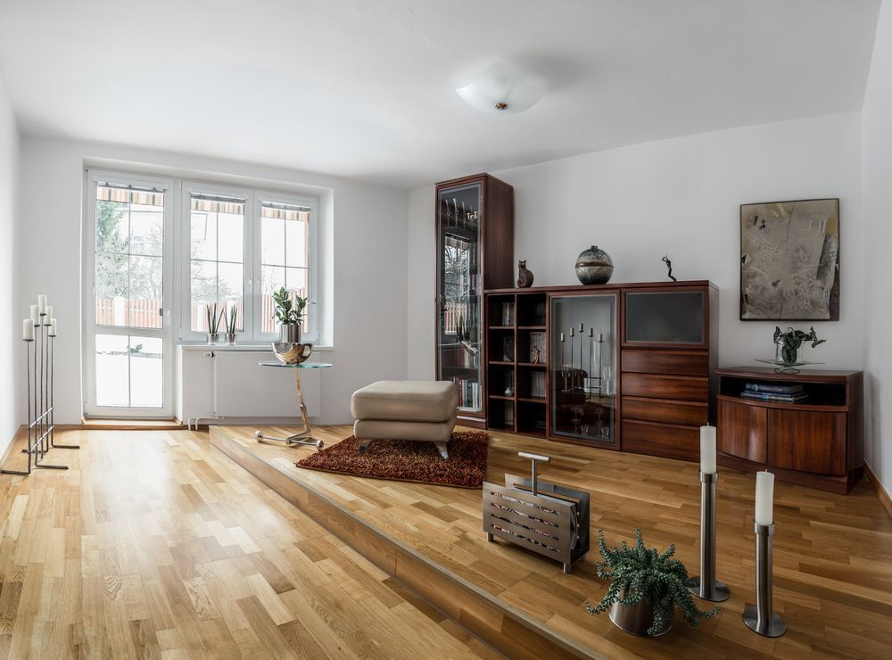 A Living Room With Hardwood Floors And White Walls — Mid Coast Flooring & Blinds In Wingham, NSW