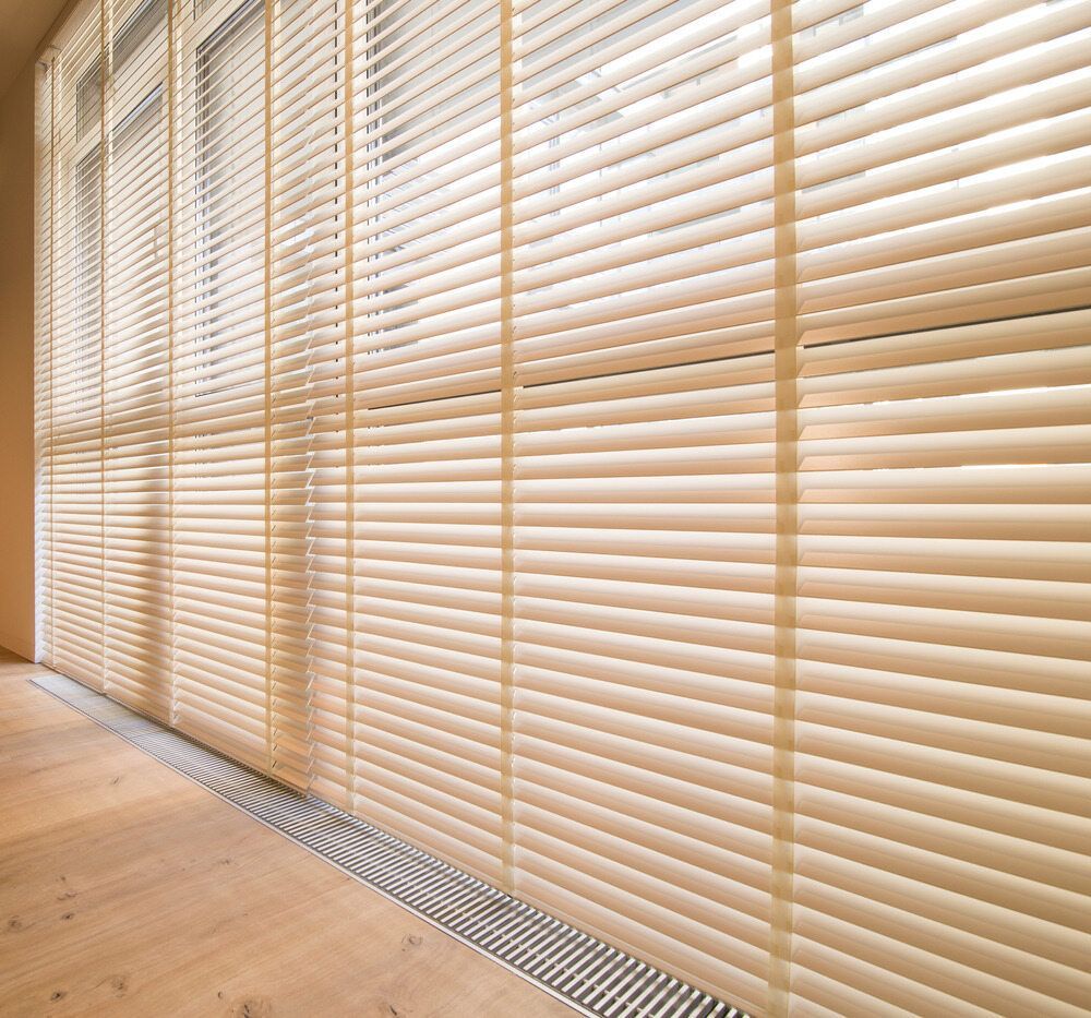 A Large Window With Blinds On It And A Wooden Floor — Mid Coast Flooring & Blinds In Taree, NSW