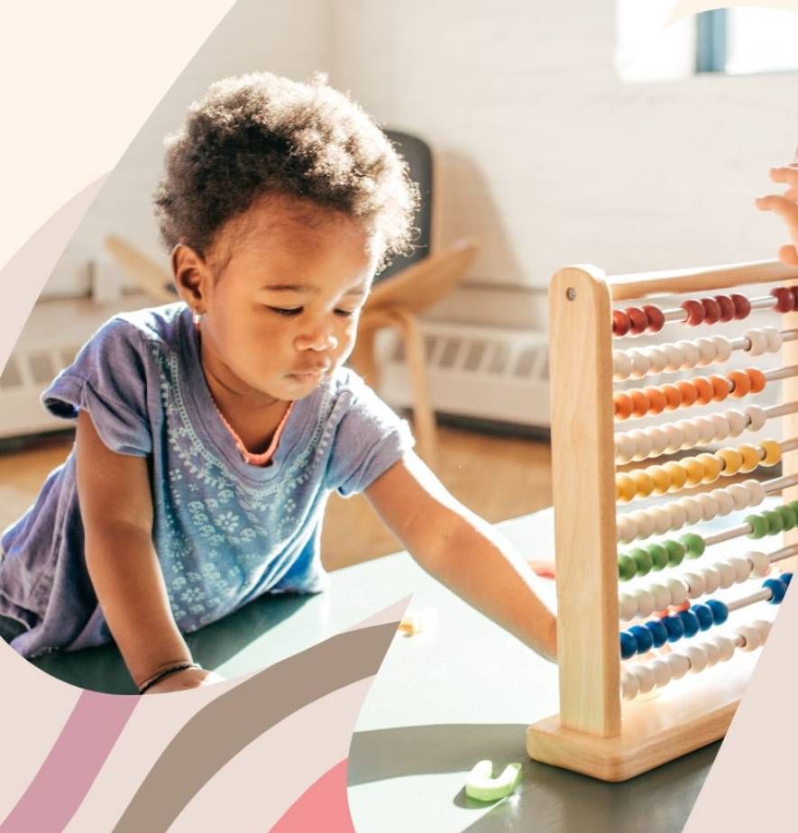 Child using a colorful abacus in a sunlit classroom, focused on counting.
