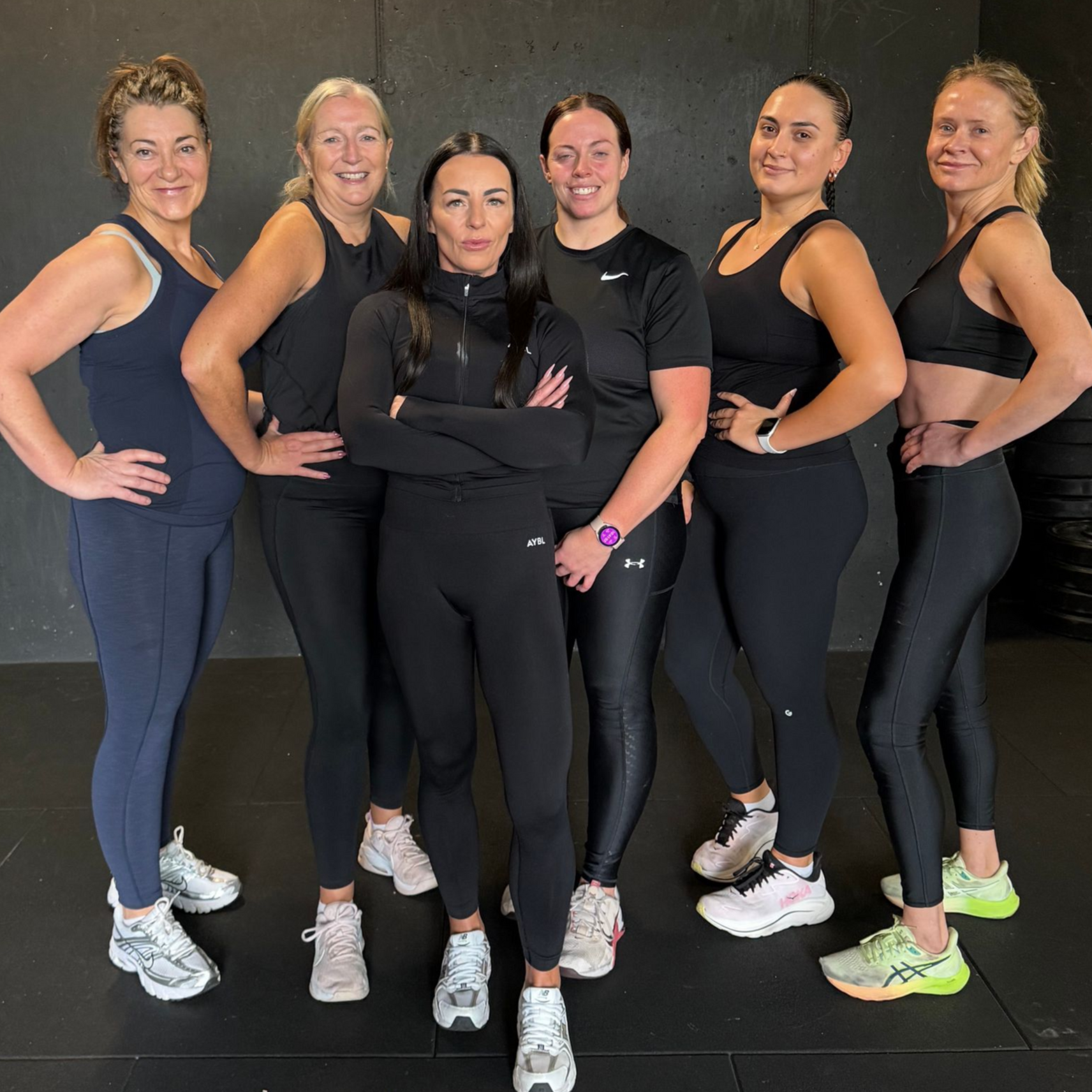Group of people smiling while exercising indoors.