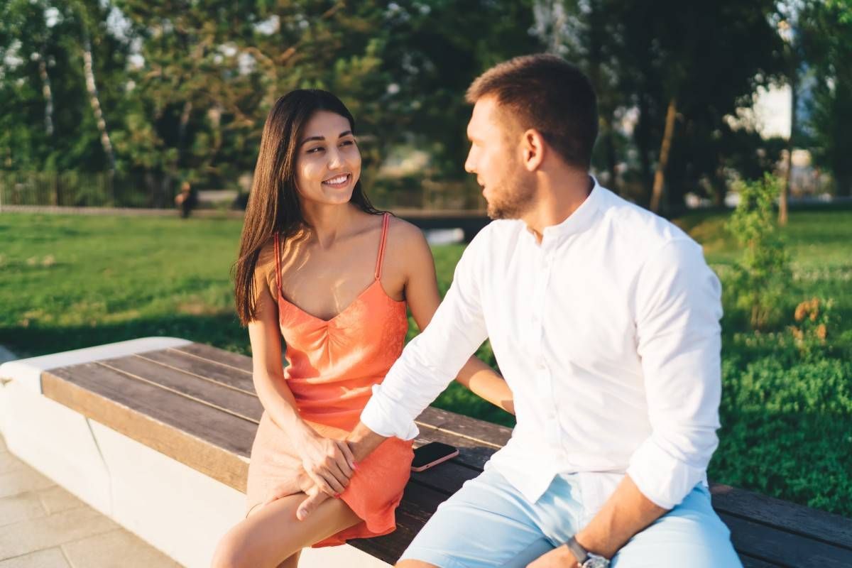 man confidently engaging with woman on date at park