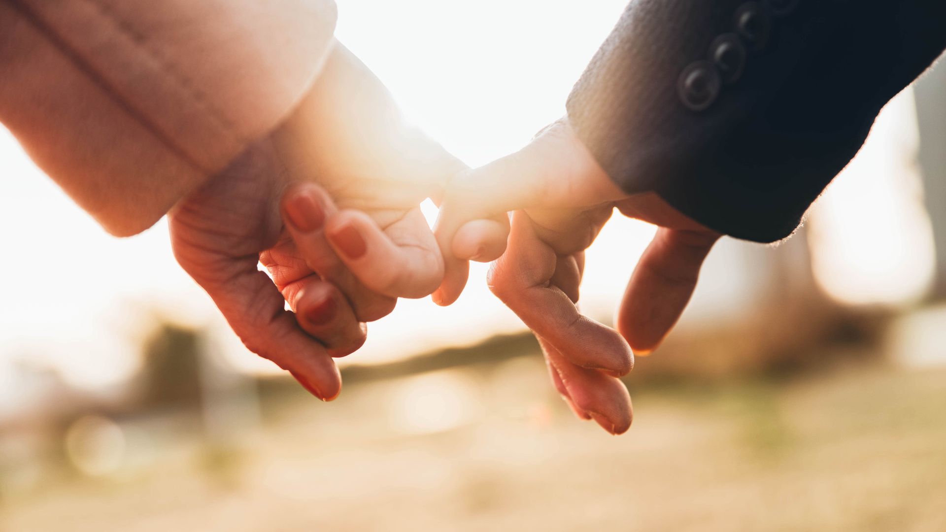 Close-up of couple holding each other’s pinkies representing trust, intimacy, and core relationship values