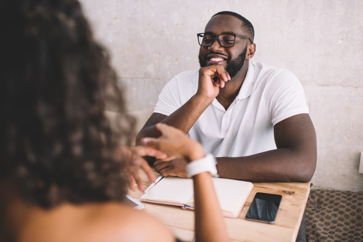 Couple on romantic date smiling and enjoying conversation during dating coaching and relationship guidance
