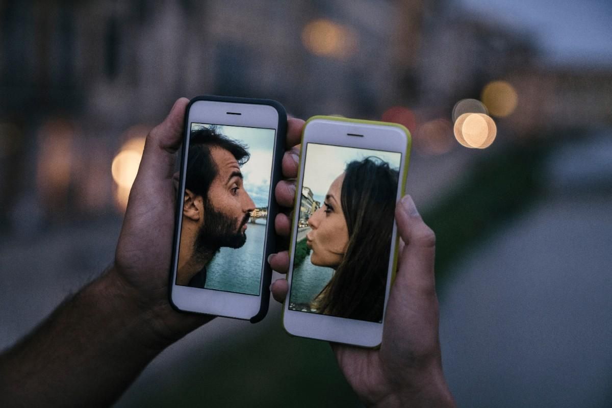 two phones displaying couple images representing dating apps versus real connection